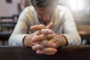 man praying in church.